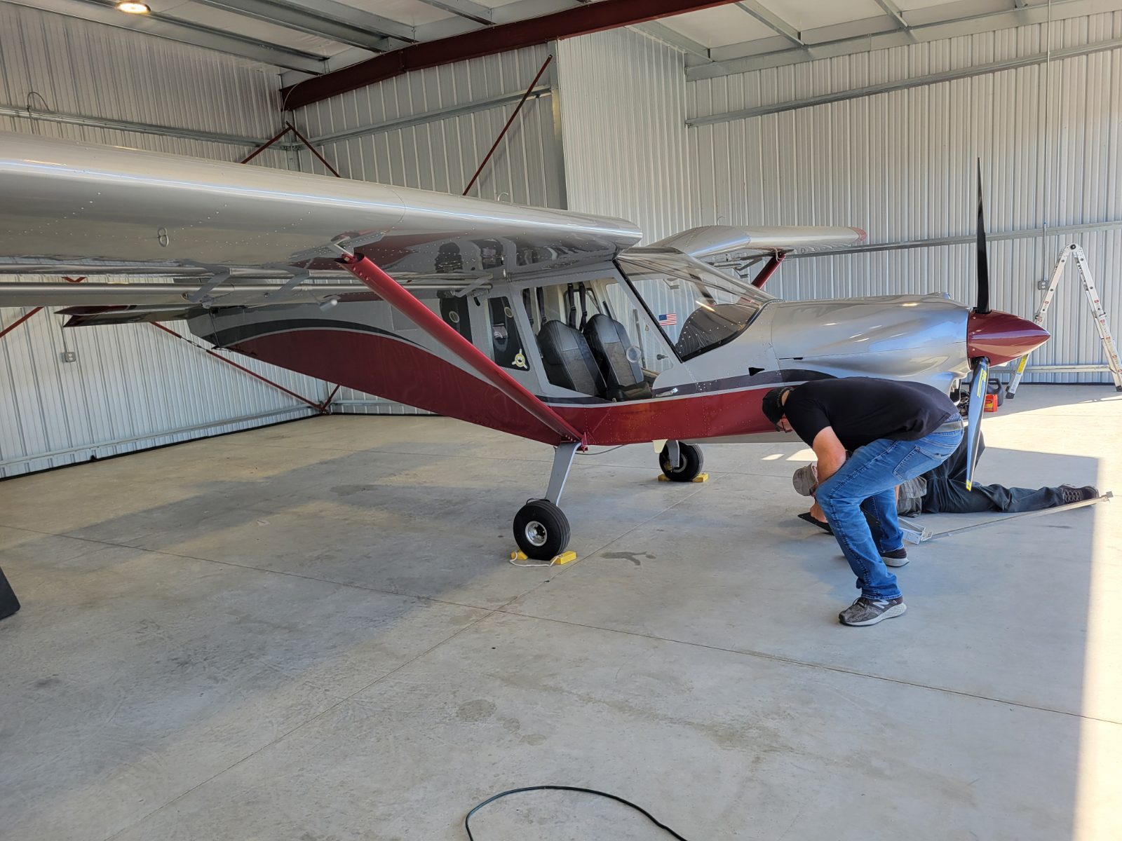 Mechanic performing maintenance on the landing gear of a light sport aircraft