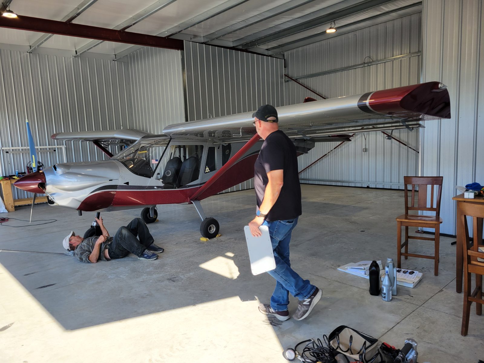 Owner and mechanic inspecting a light sport aircraft in a hangar